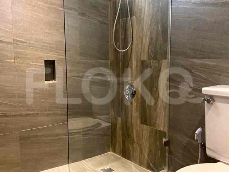 A close-up view of a modern shower with wood-patterned tiles.