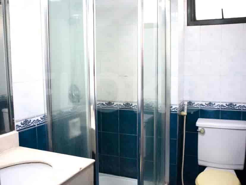 Kamar mandi modern dengan bilik shower dan toilet.