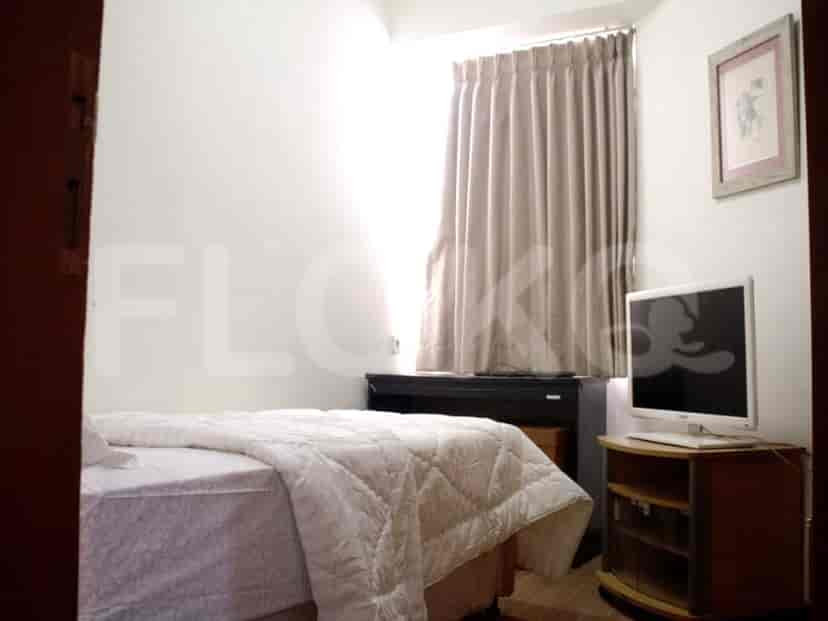 Kamar tidur yang nyaman dengan tempat tidur ganda, TV, dan dekorasi sederhana.