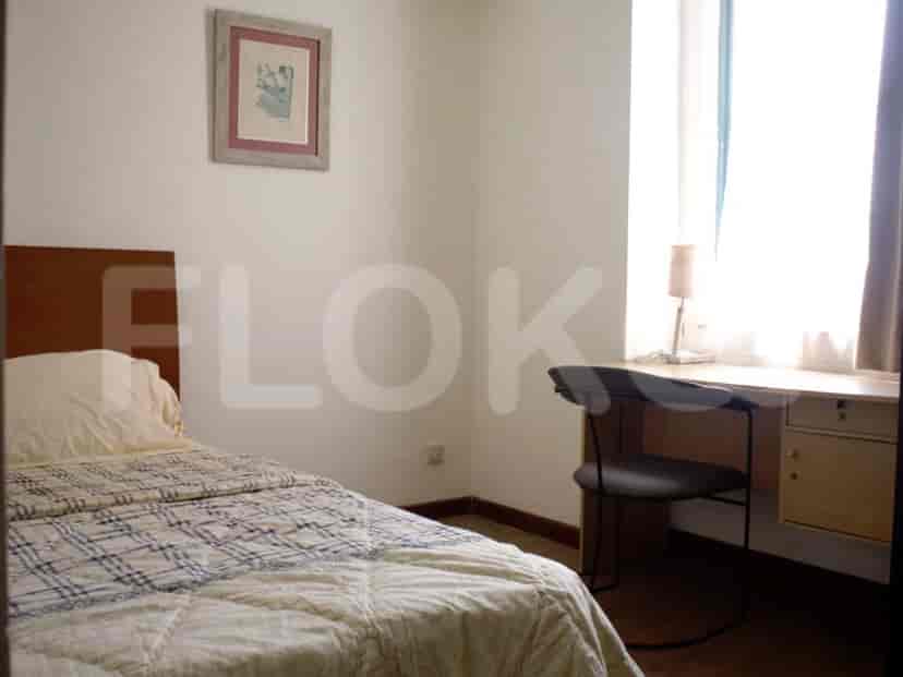 Kamar tidur dengan tempat tidur single, meja, dan desain minimalis.