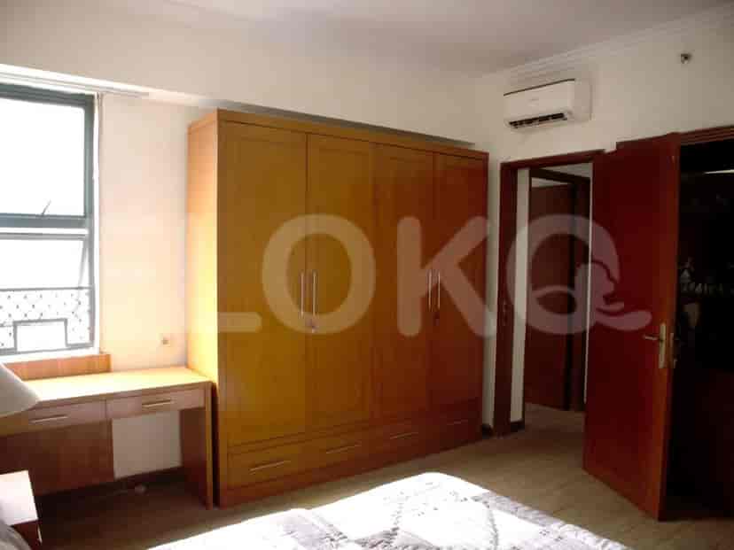 Kamar tidur utama dengan lemari pakaian besar, meja, dan penyejuk udara.