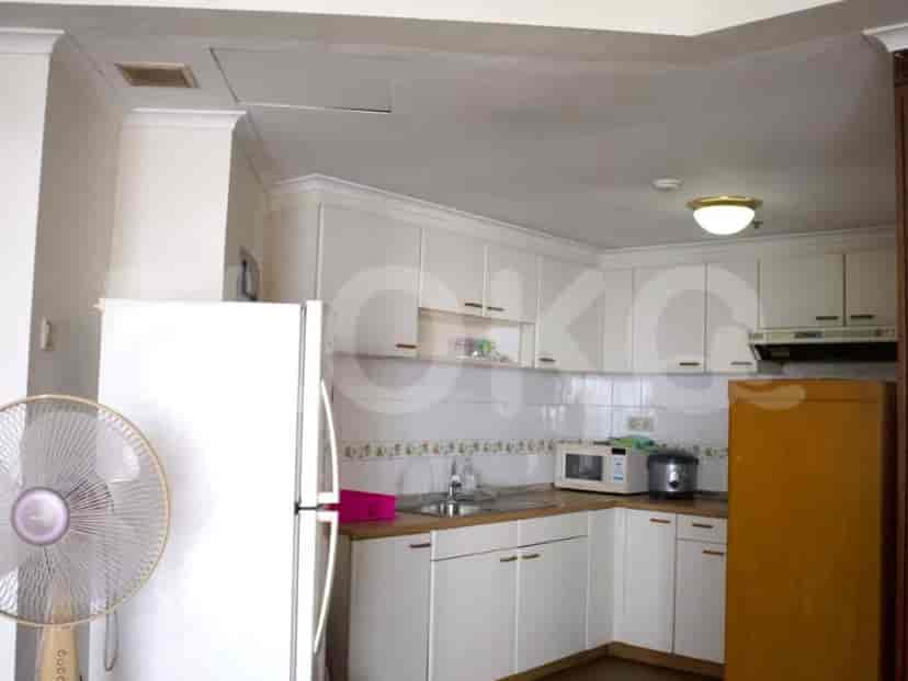Dapur yang bersih dan modern dengan lemari putih, peralatan, dan tata letak yang fungsional.