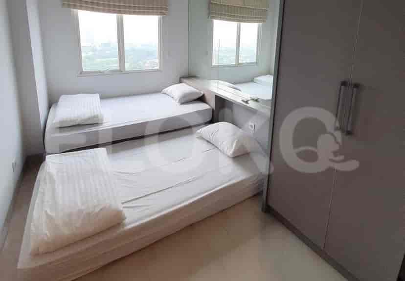 A small bedroom with two single beds and a large mirror.