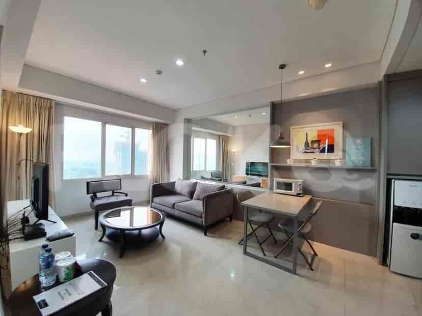 A well-lit living area featuring a sofa, dining table, and a large mirror.