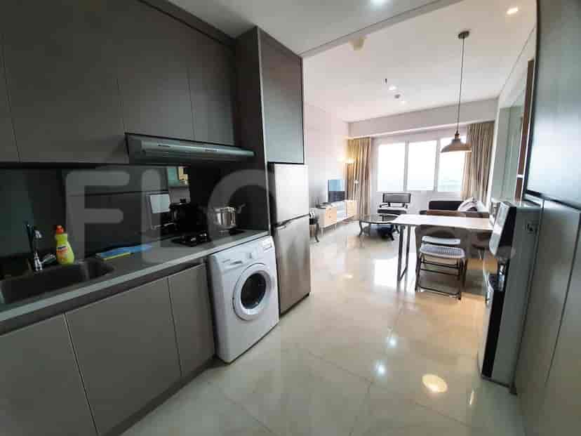A kitchen area with appliances and a glimpse into the living area.