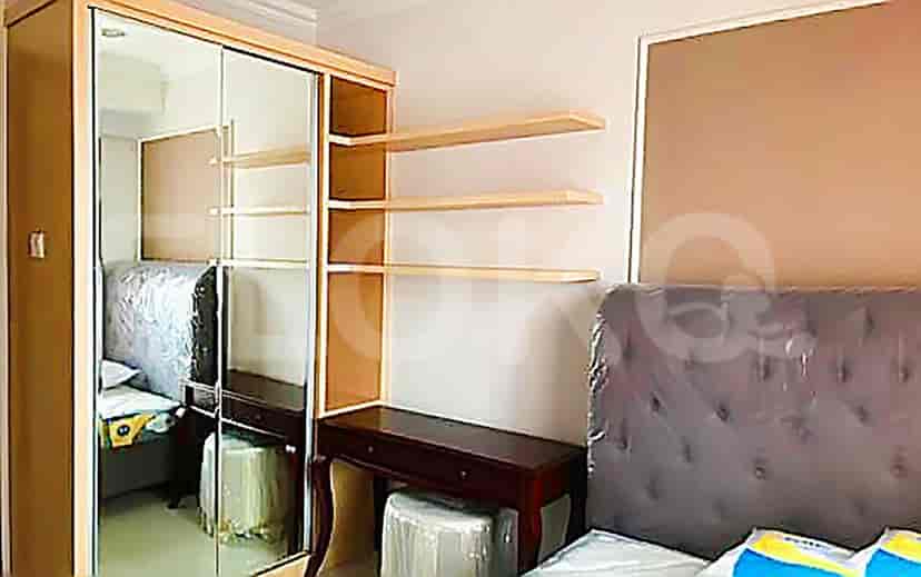 A bedroom with a bed, wardrobe, and shelves, designed for maximizing storage and space.