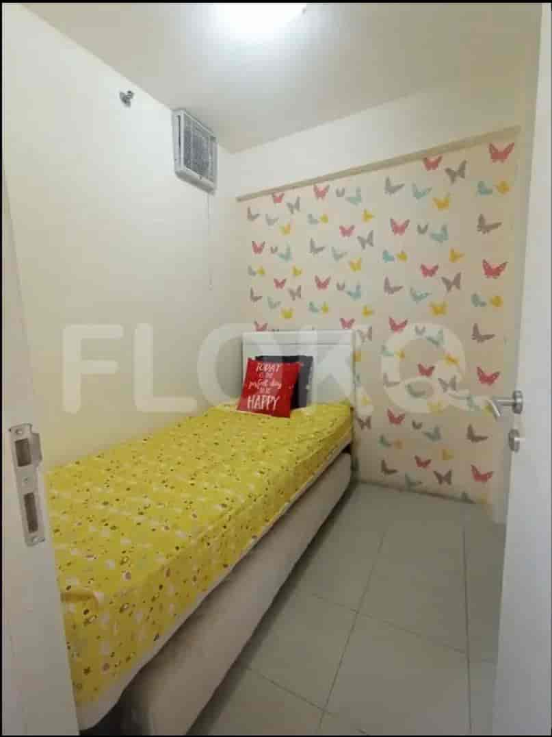 Kamar tidur kecil dengan tempat tidur tunggal dan wallpaper kupu-kupu.