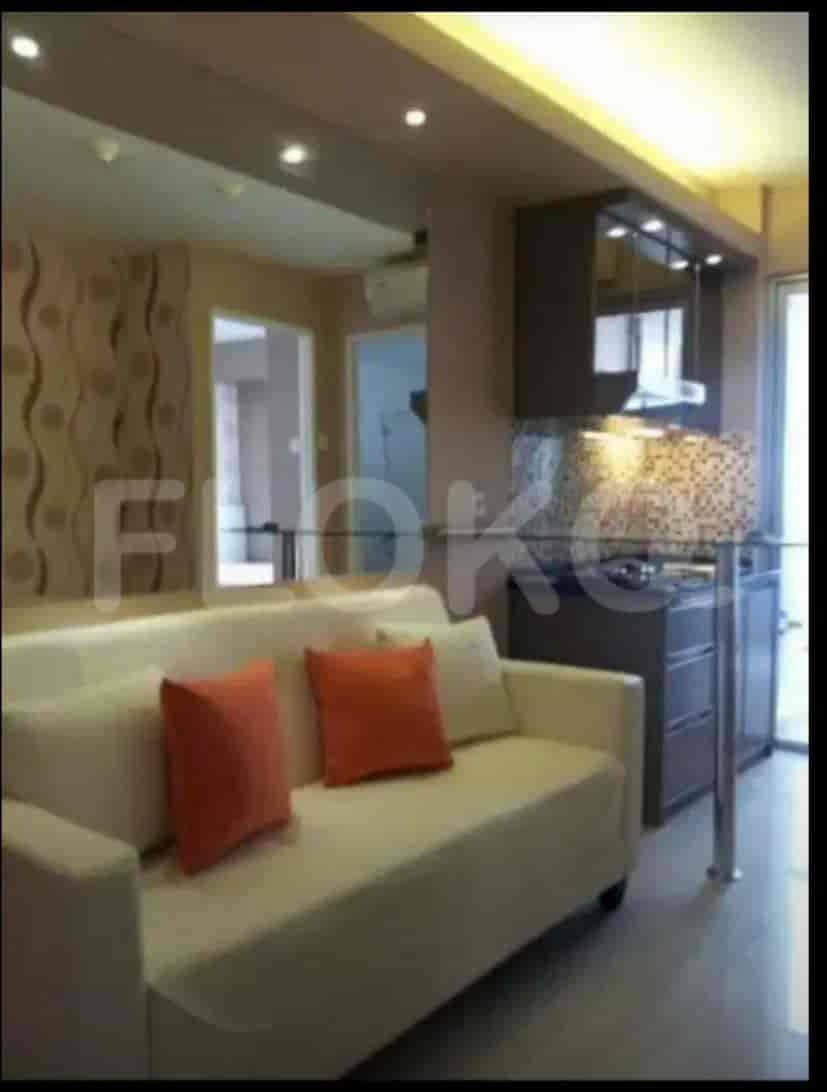 Area hidup dengan sofa, dapur, dan cermin.