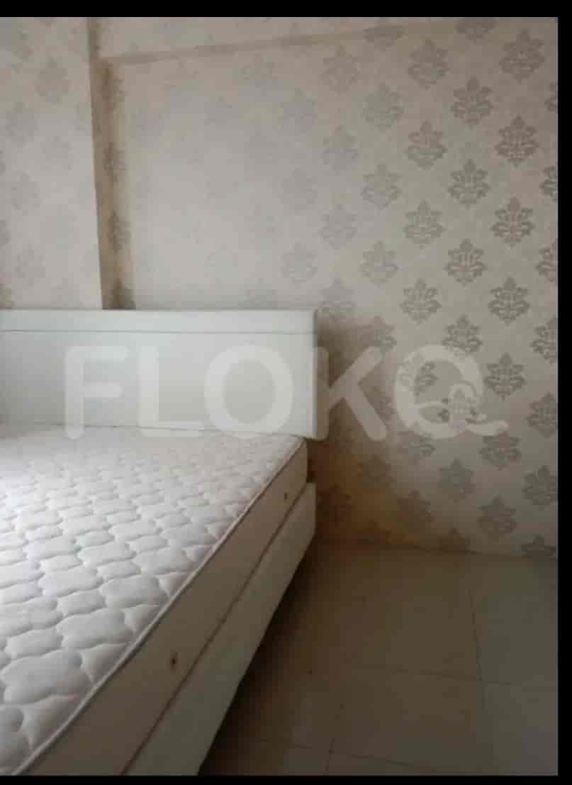 Kamar tidur dengan tempat tidur dan wallpaper bermotif.