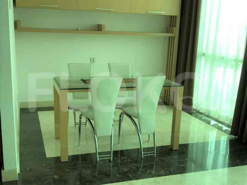 Dining area with a glass-topped table and four chairs.