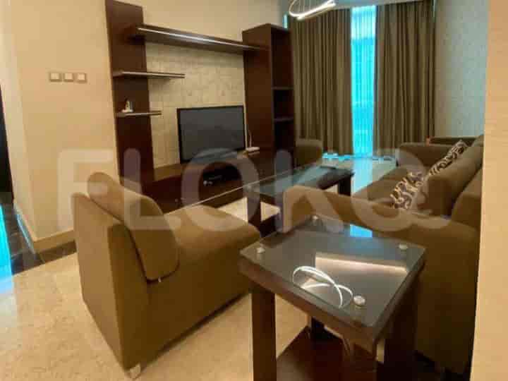 A living room with a brown sofa, coffee tables, entertainment unit, and a TV.