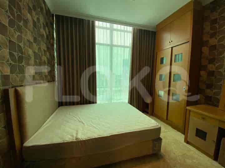 A bedroom with a bed, wardrobe, and window.