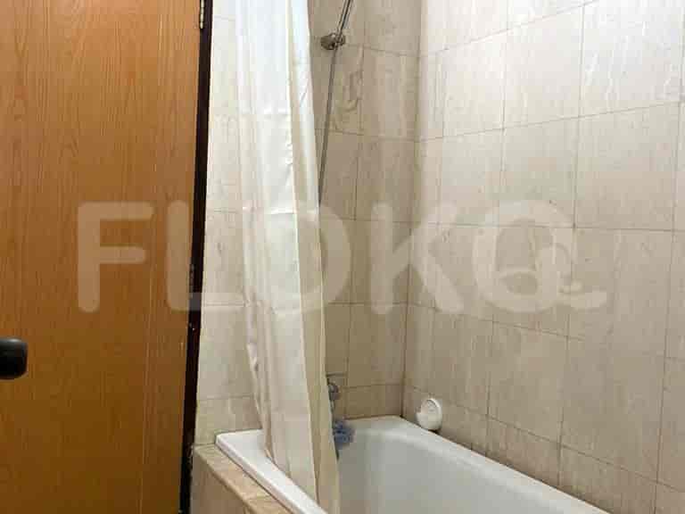 A small bathroom with tiled walls, a bathtub, and a shower curtain.