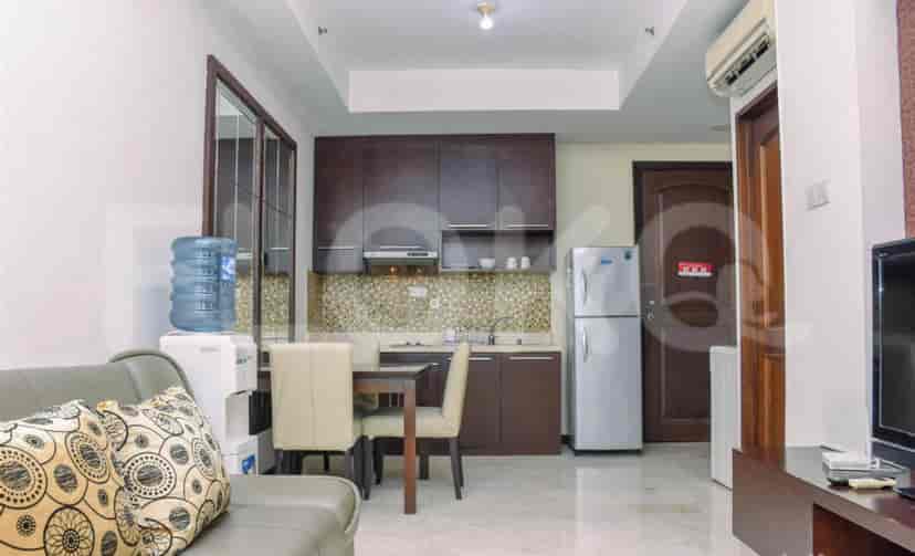 A compact kitchen with a dining table and a refrigerator.