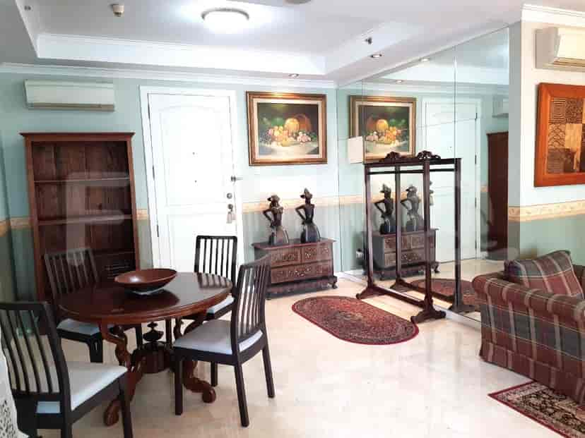 A well-decorated living room with a dining area, artwork, and traditional furniture.