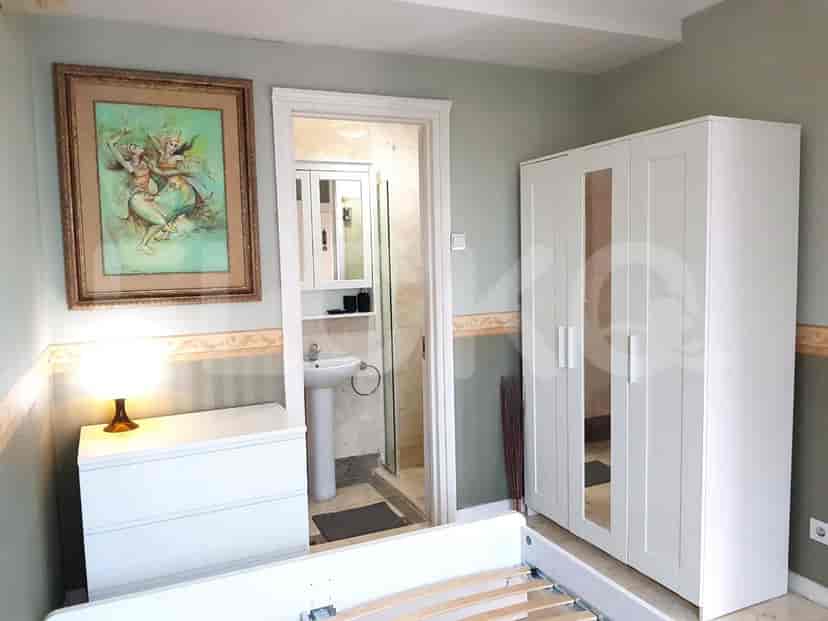 A bedroom with a bed, wardrobe, and bathroom entrance.
