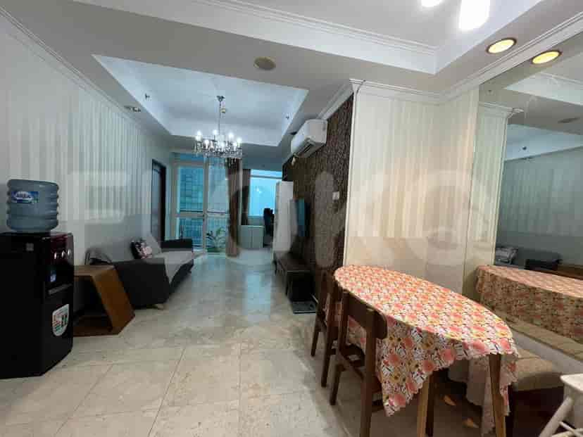 A well-lit living room with a dining area, sofa, and marble flooring.