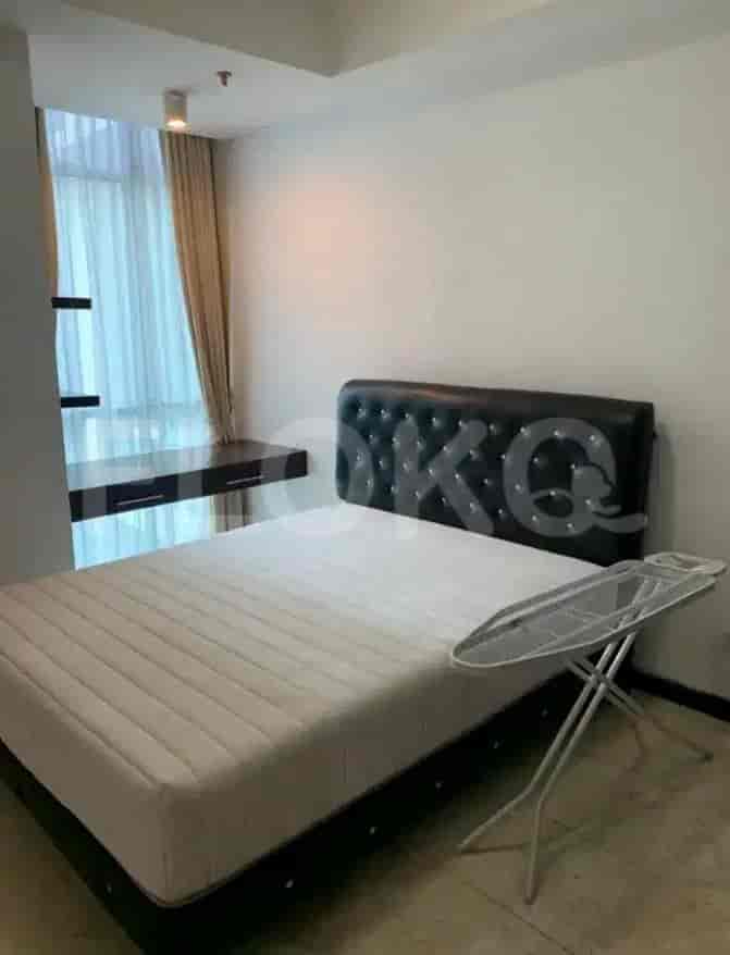 A bedroom with a bed, a wall-mounted desk and curtains.