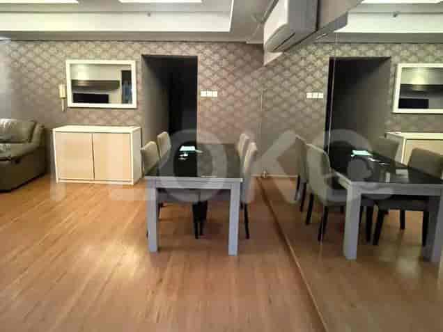 Open space with a dining table, chairs, and a leather sofa.