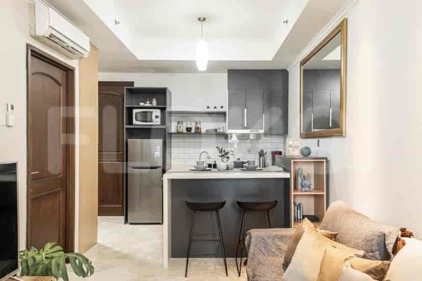 A modern kitchen with a breakfast bar and a small living area.