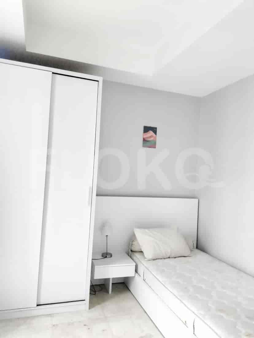 A compact bedroom with a single bed, white wardrobe, and minimalist decor.