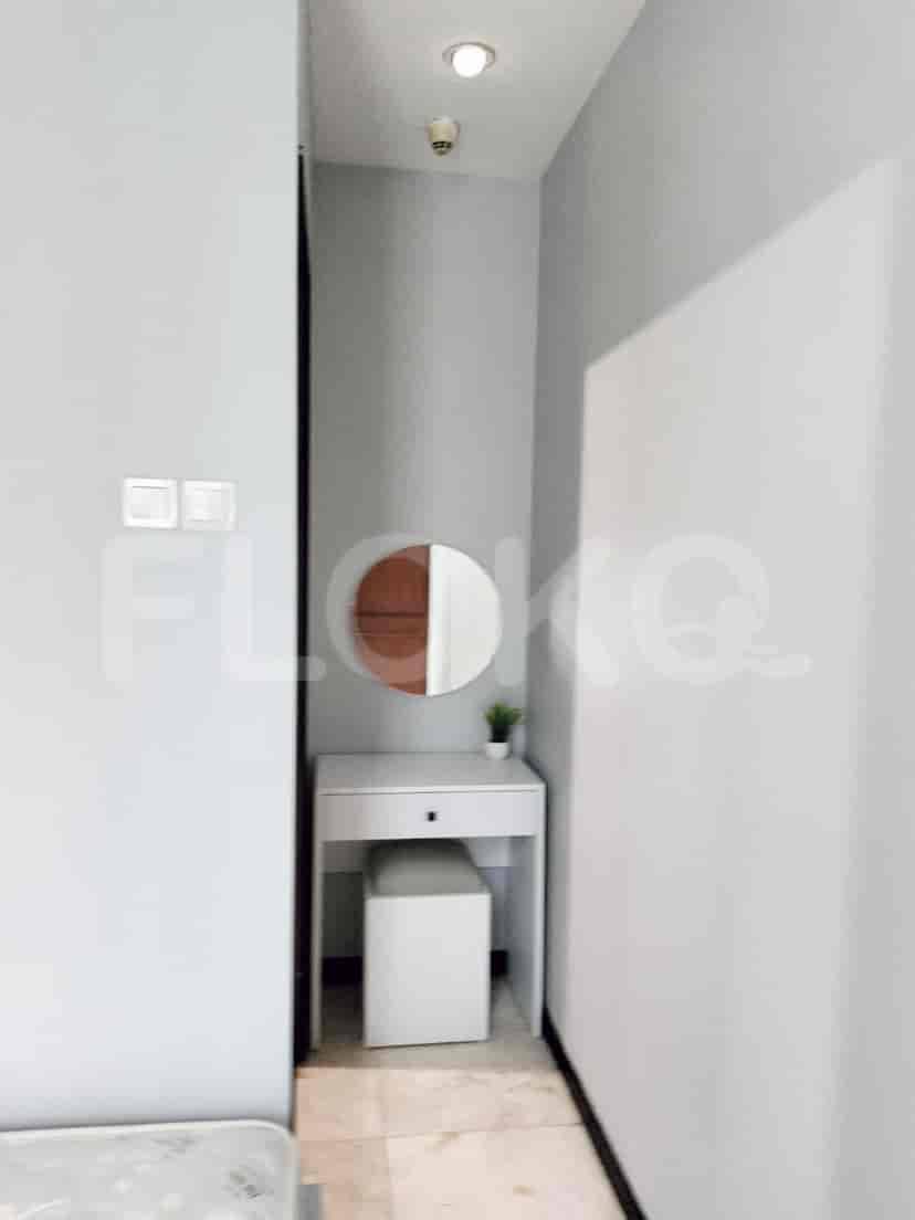 A small hallway leading to the bedroom with a vanity table and mirror.