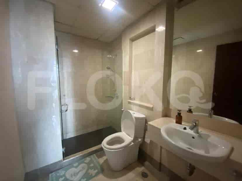 A modern bathroom with a glass shower enclosure, toilet, and vanity with a sink.