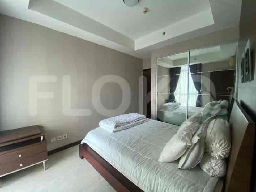 A bedroom with a mirrored sliding closet, a bed with cozy bedding, and a chest of drawers.