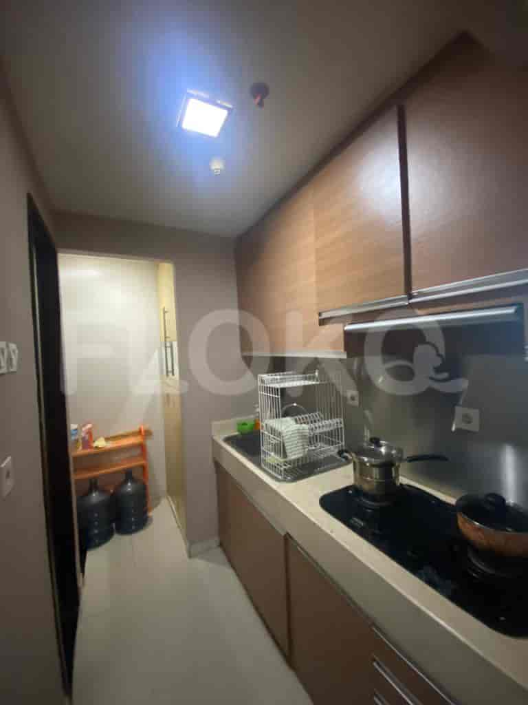 A compact kitchen with wooden cabinets, an electric stove, and stainless steel appliances.