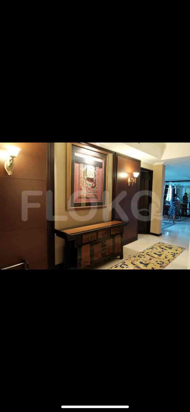 A hallway featuring a decorative sideboard with a picture and wall-mounted lights.