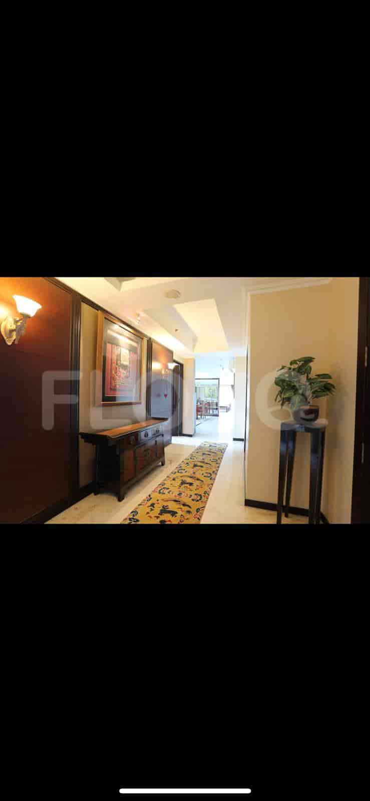 A well-lit hallway with a runner rug and a decorative table.