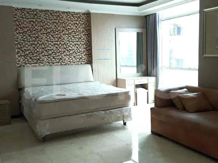 Bedroom with queen-size bed, small sofa, and vanity.