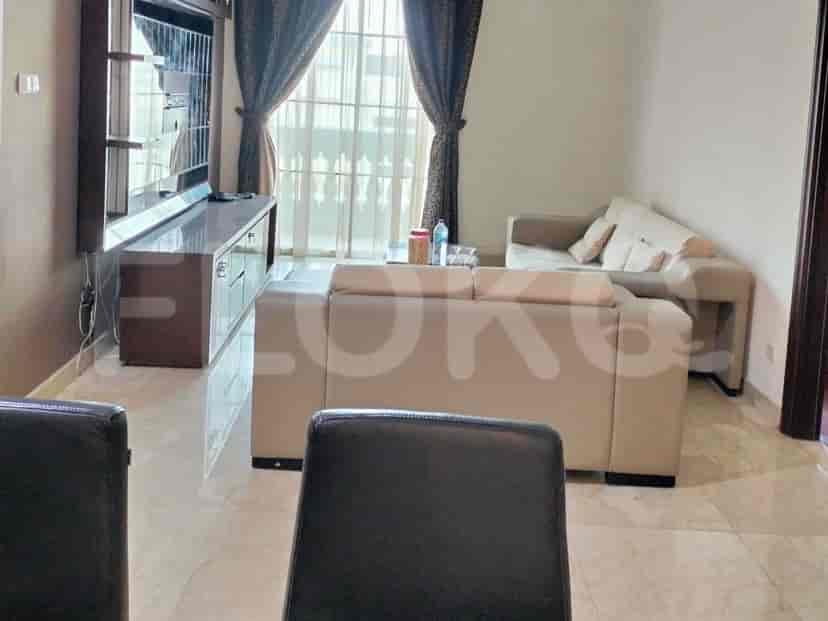 Modern living room with a grey sofa, entertainment unit, and large windows with curtains.