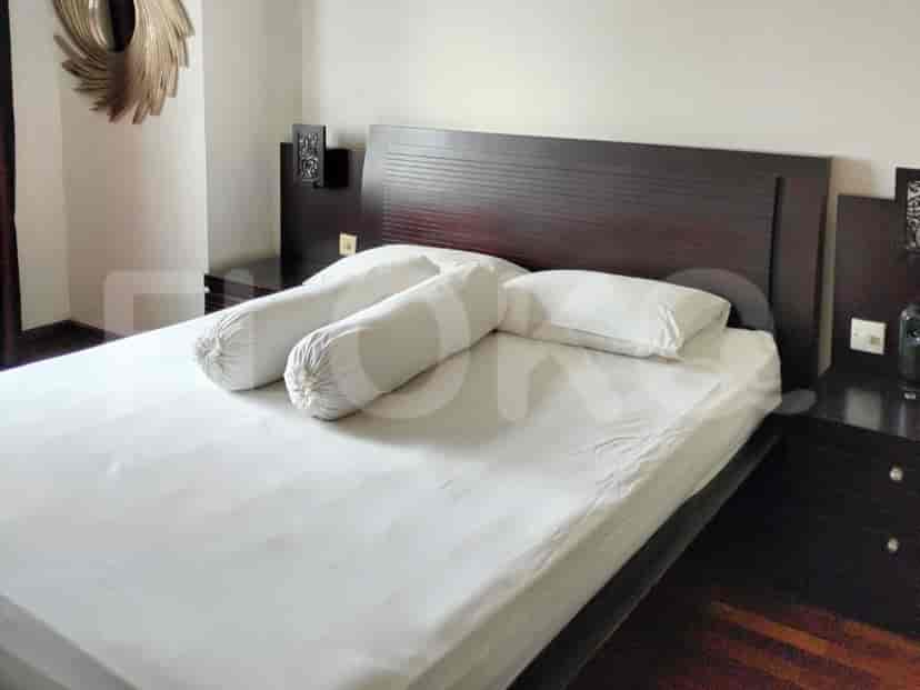 A bedroom featuring a bed with white bedding and side tables.