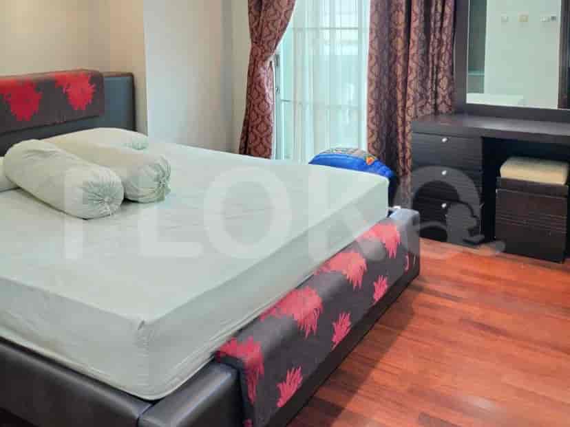 Bedroom with a bed featuring red accents, and curtains.