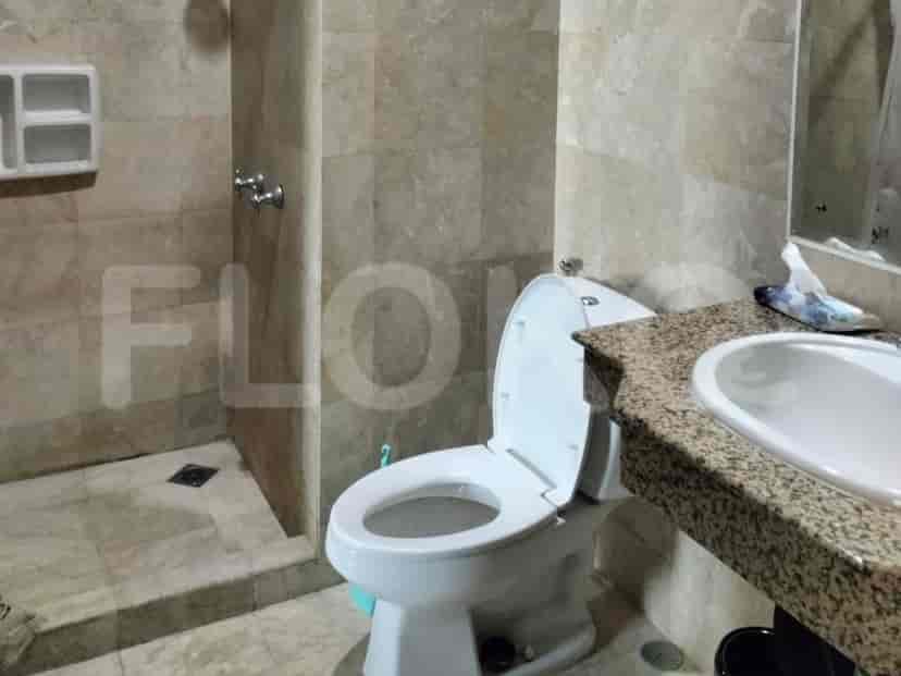 Bathroom with a toilet, sink and shower area.