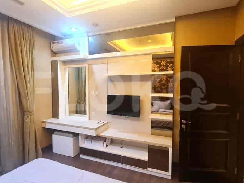 The master bedroom with a TV, a vanity, and a built-in closet.