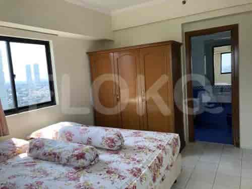 A bedroom featuring a bed with floral bedding, a large closet, and a window with a view.