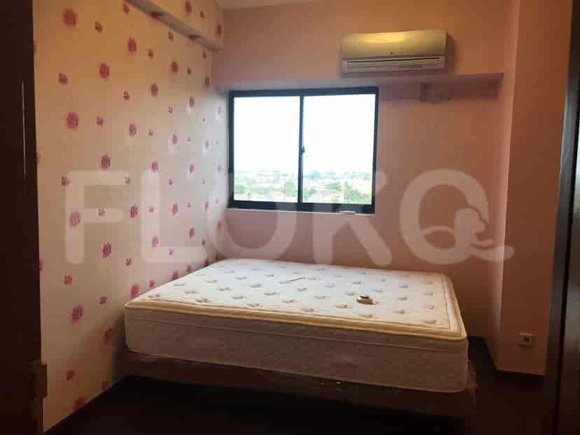 A small bedroom with a bed and window.