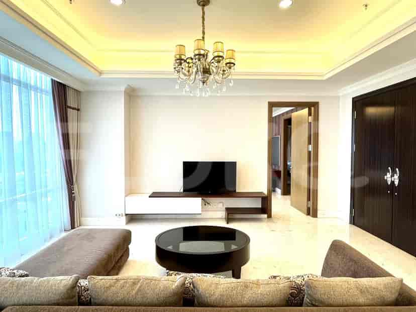 Luxurious living room with a crystal chandelier, marble floor, and dark wood accents.