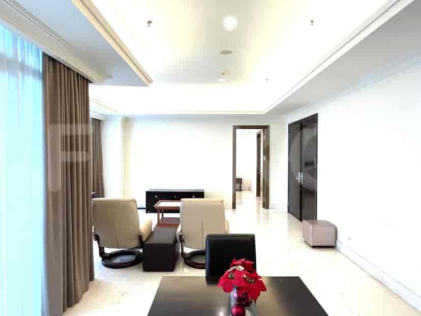 A living room with furniture arrangements, including recliner chairs, a coffee table, and a dark cabinet.