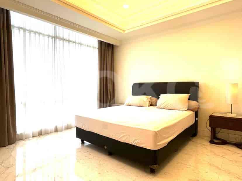 A bedroom with a bed, nightstand, and large window.