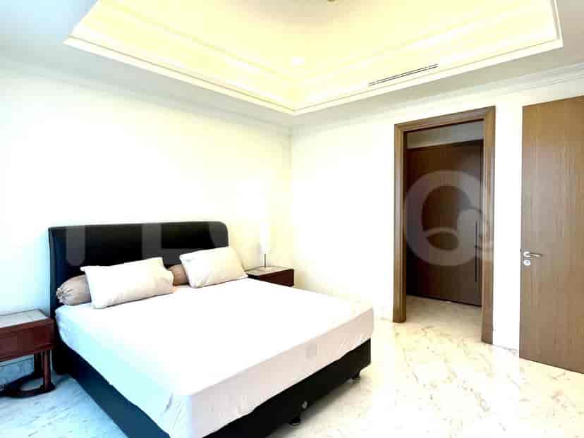 A bedroom with a bed, nightstand, and door leading to a closet.