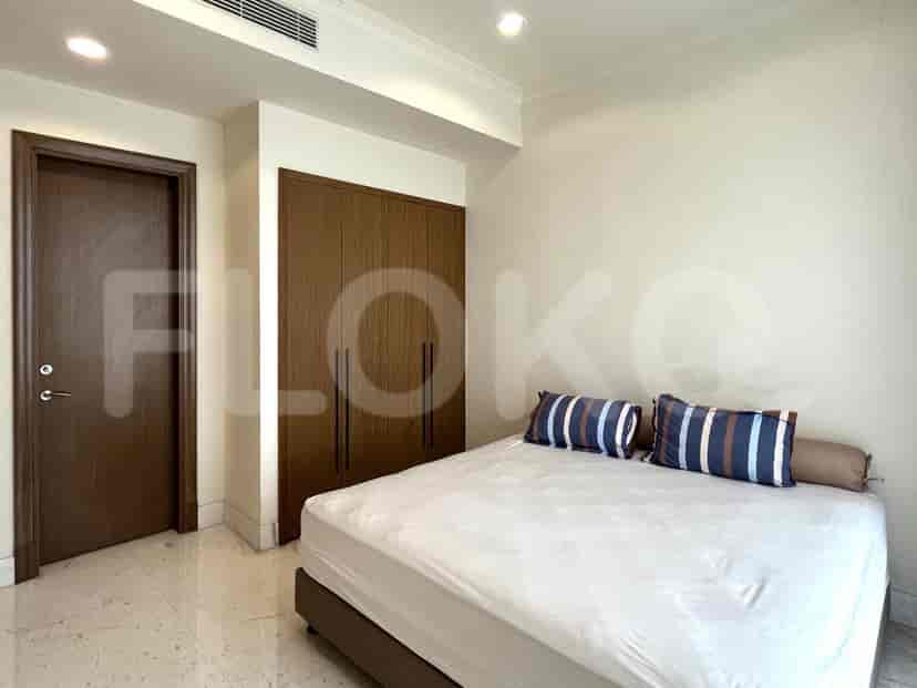 A bedroom with a bed, doors to closet, and a window.
