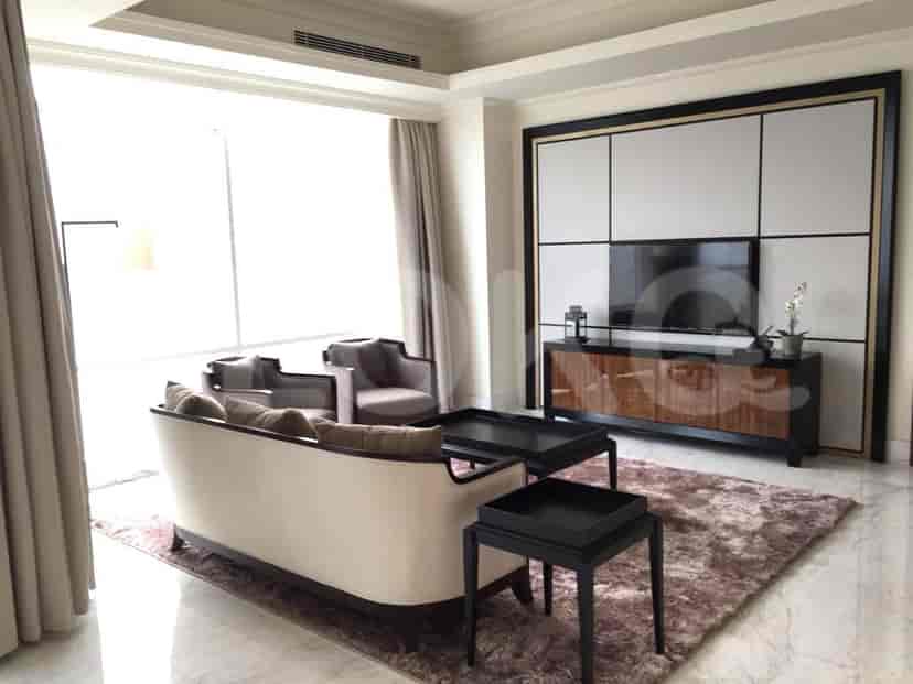A living room with a sofa, armchairs, a TV, and a coffee table.