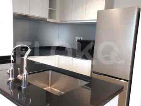 Dapur modern dengan wastafel baja tahan karat, meja hitam, dan kulkas.