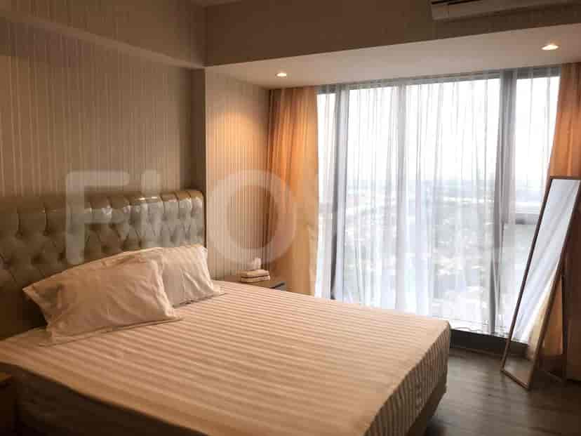 Kamar tidur dengan tempat tidur, cermin, dan gorden.