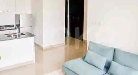 Tata letak terbuka yang menampilkan area dapur dan ruang tamu, dengan sofa biru dan meja dapur.
