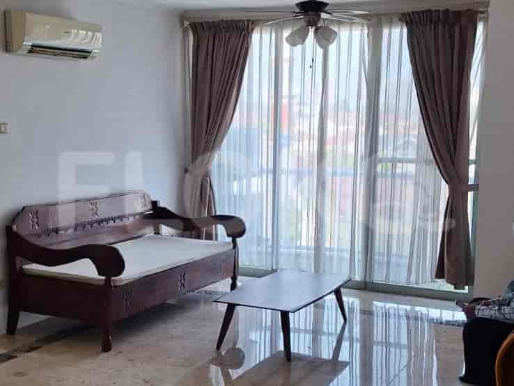 A living room with a wooden bench, a coffee table, and a balcony with curtains.