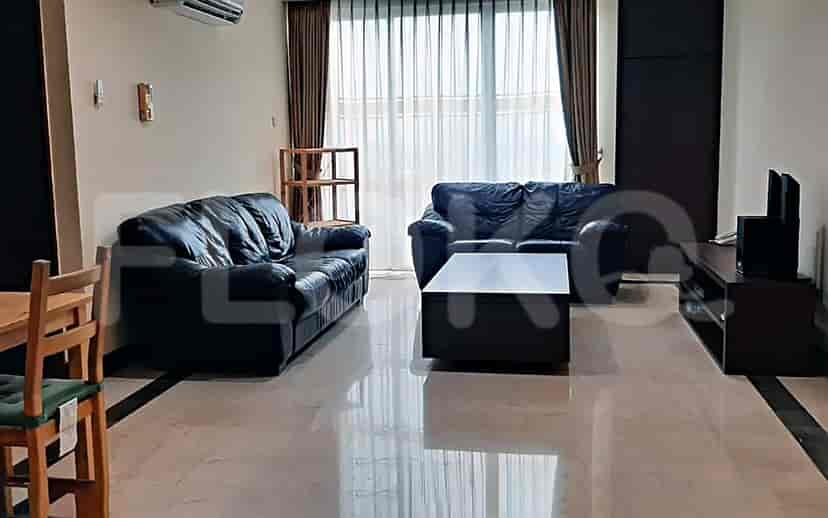 A living room with two black sofas, a coffee table, and a TV.